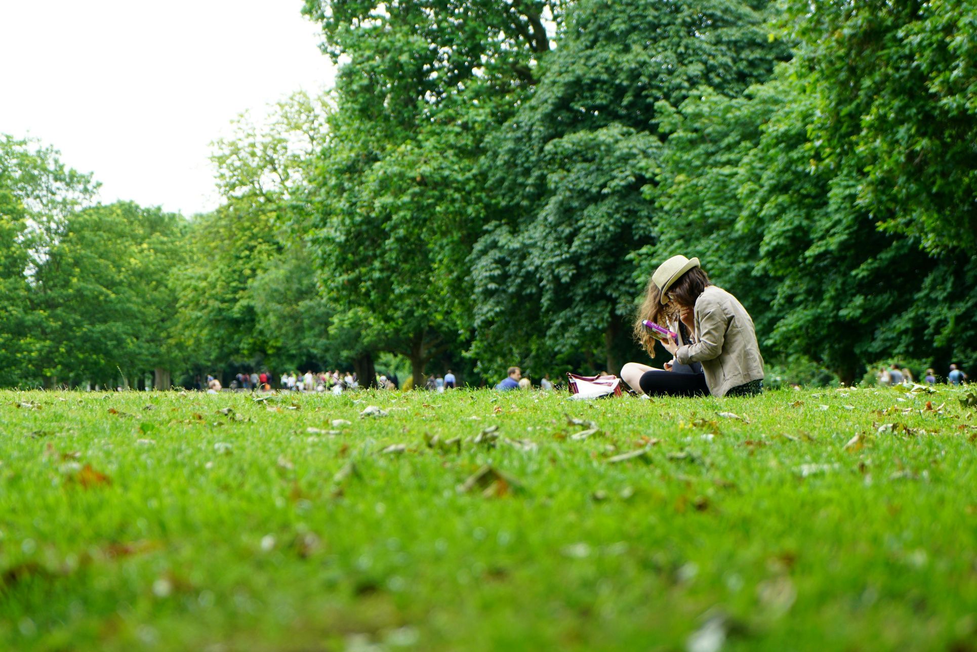 People enjoying a sunny day in Priory Gardens, Orpington. The photo shows a woman relaxing on the grass with trees in the background, highlighting the park’s peaceful atmosphere and community appeal. Perfect for SEO targeting Priory Gardens Orpington, parks in Orpington, green spaces near Orpington homes, and family-friendly outdoor spaces.