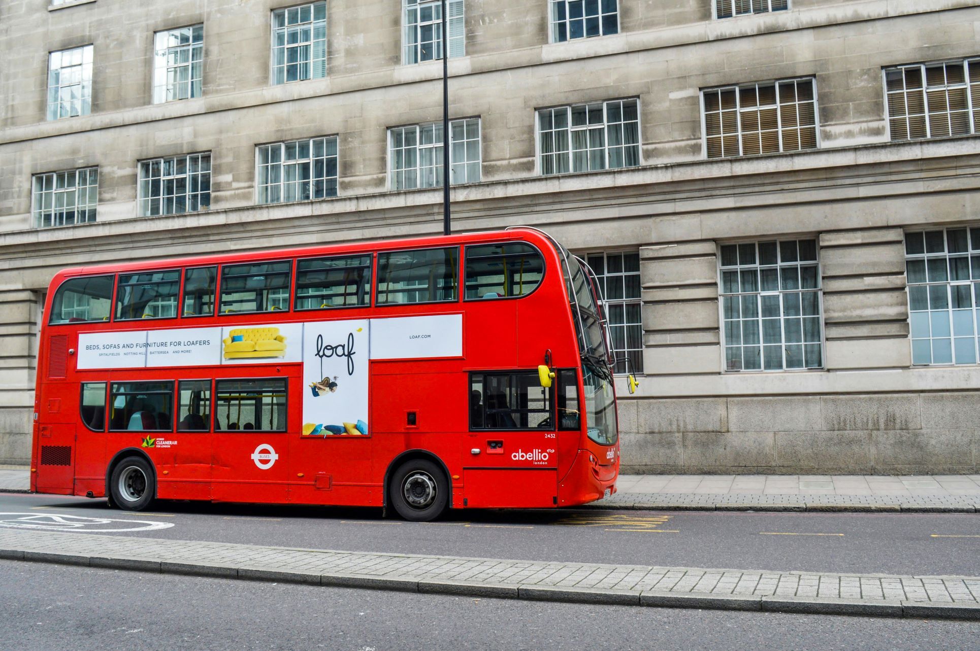 A classic red double-decker London bus stopped on a quiet urban street beside a stone building. This iconic transport symbol represents the convenience of public transport links across London and surrounding areas such as Orpington, Beckenham, Bromley, and Lewisham. Ideal for illustrating blogs about commuting, property values near transport hubs, and the importance of strong bus and train connections when buying or selling a home.
