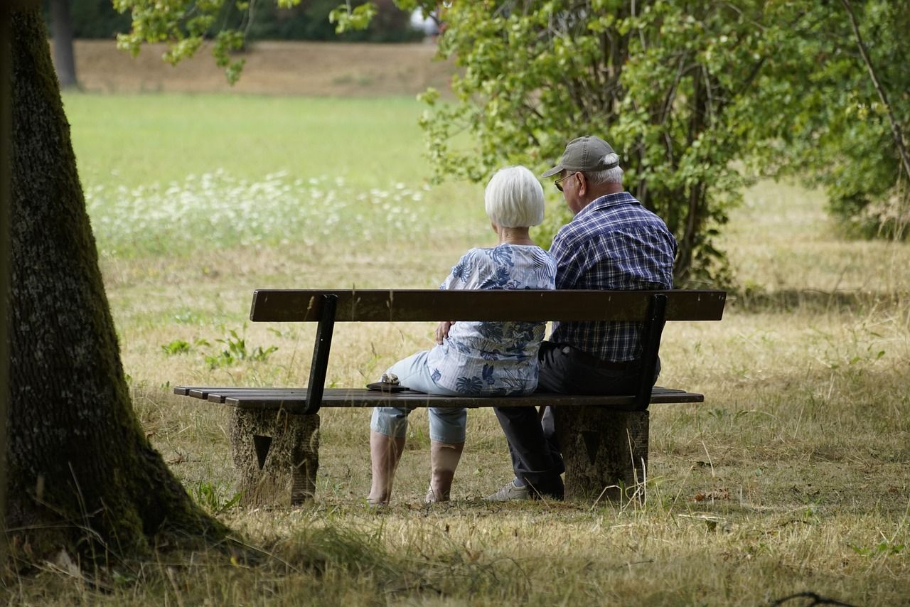 Elderly couple sitting peacefully on a park bench, symbolising retirement living and lifestyle choices. Integra Estates – trusted estate agents in Beckenham, Bromley, Orpington, and across South East London, supporting downsizing, assisted living, and property advice for retirees