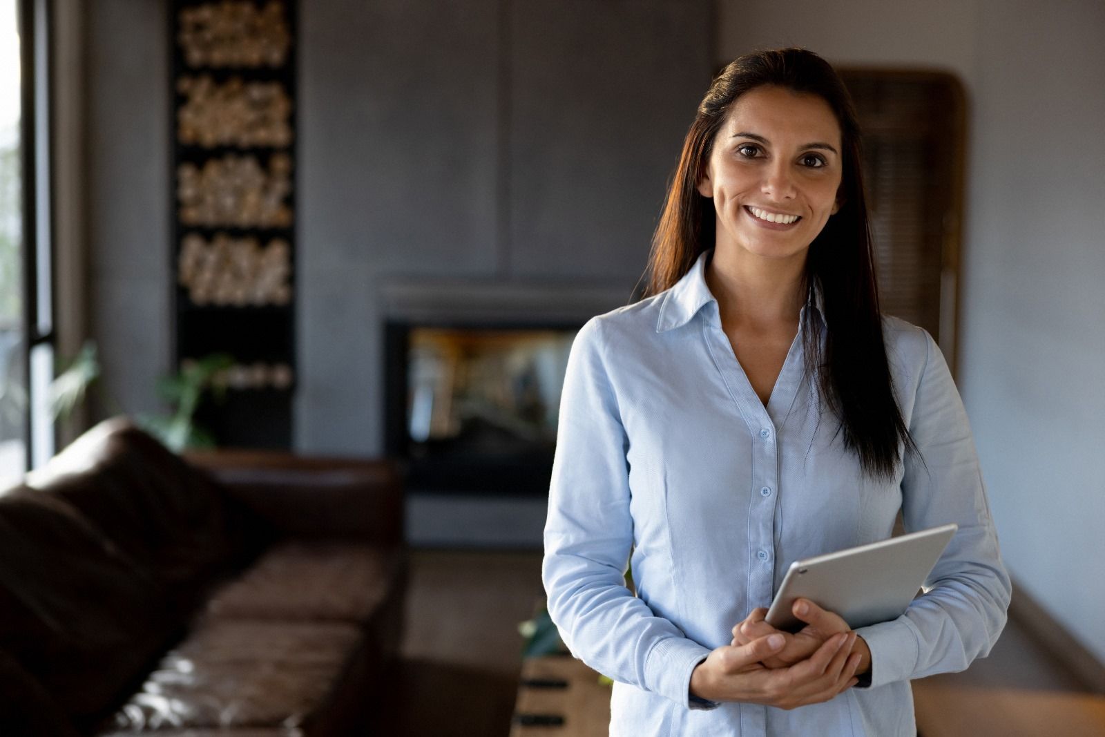 Professional Beckenham estate agent smiling while holding a tablet, representing trusted property valuations and client-focused estate agency services